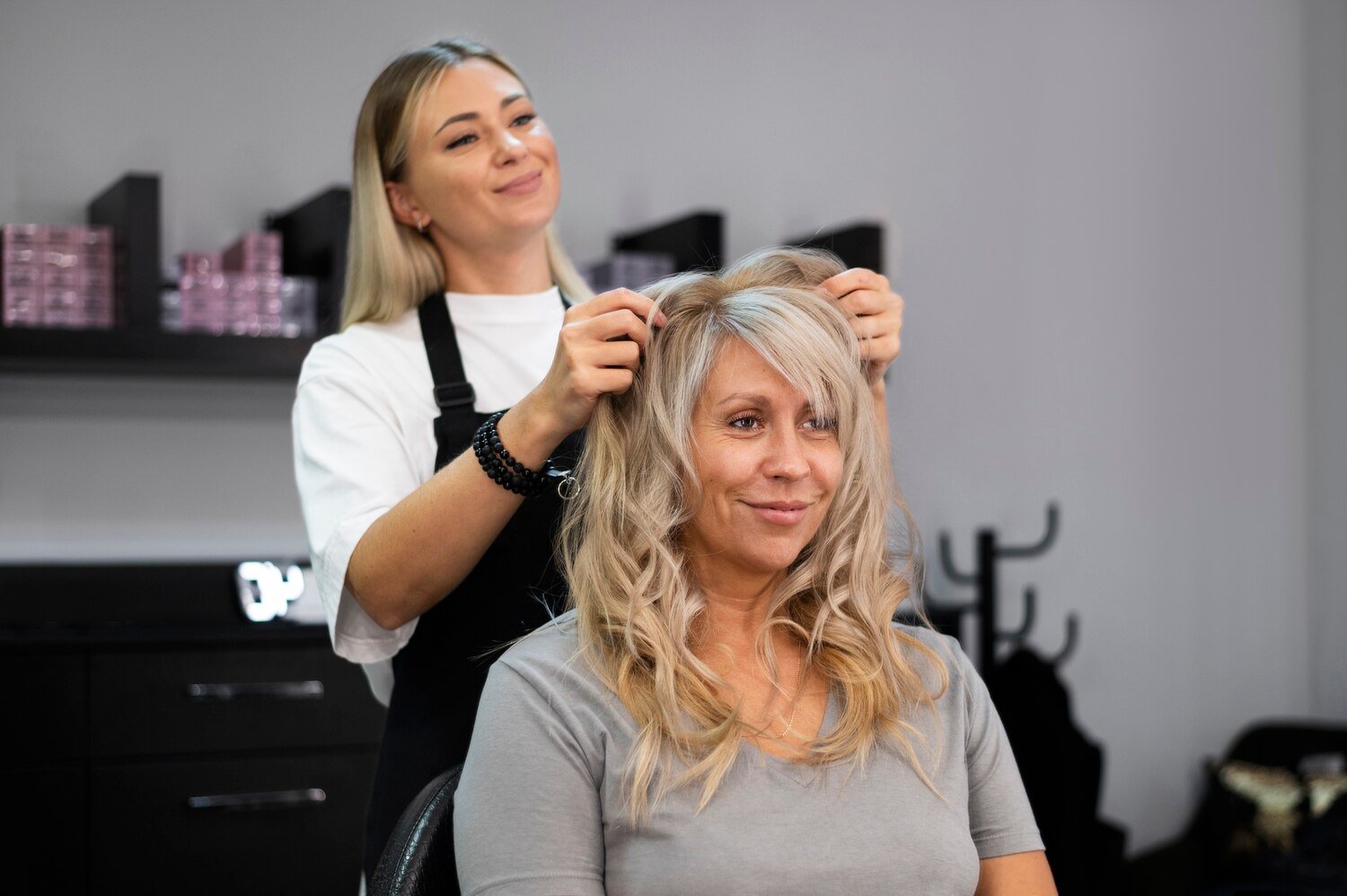 Stilistă care realizează coafura unei cliente